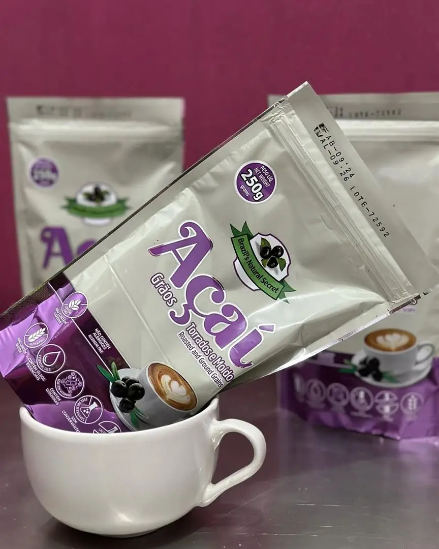 A 250 g pouch of roasted, ground açaí seed resting in a cup, with more pouches behind it.